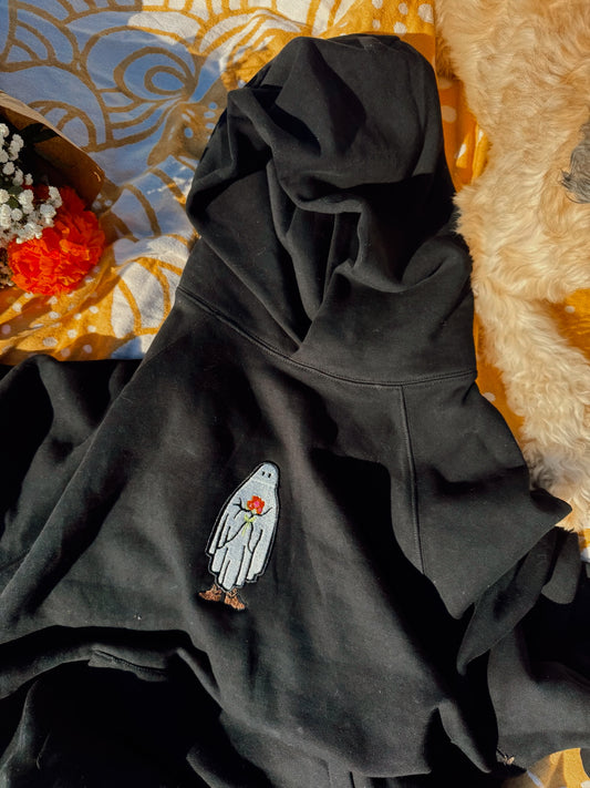 Oversized black hoodie embroidered with a fall cowboy ghost design with flowers in the background